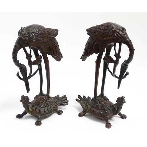 1062 - A pair of Japanese cast sculptures modelled as a stylised crane standing on a tortoise. Approx. 7 1/... 