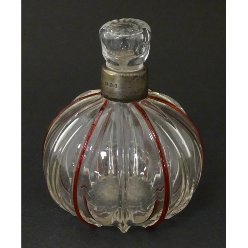 240 - An early 20thC glass scent / perfume bottle with red glass detail and silver collar hallmarked Birmi... 