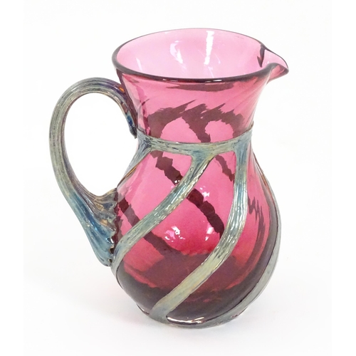 263 - A cranberry glass jug with silver overlay detail by Sileda Ltd. Approx. 3 3/4