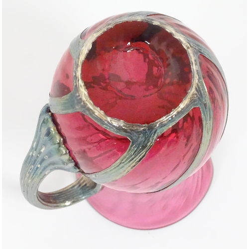 263 - A cranberry glass jug with silver overlay detail by Sileda Ltd. Approx. 3 3/4