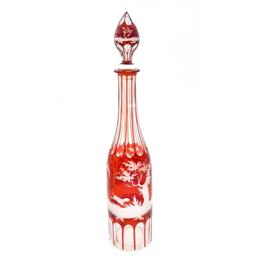 272 - A glass decanter with red and etched detail depicting a landscape with dog, deer, etc. With an assoc... 