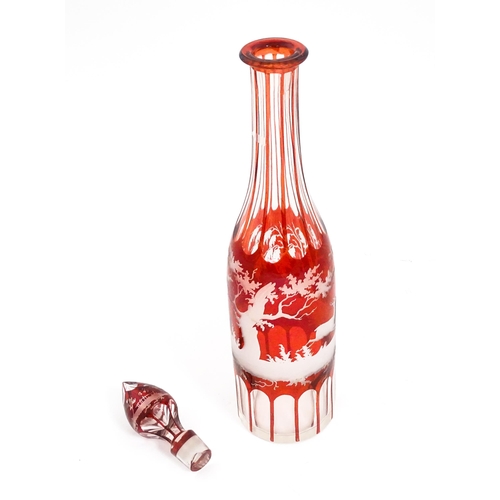 272 - A glass decanter with red and etched detail depicting a landscape with dog, deer, etc. With an assoc... 