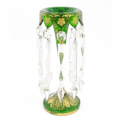 274 - A Victorian green glass table lustre with gilt foliate decoration and clear glass drops. Approx 13 1... 