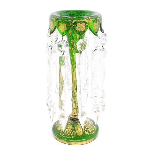 274 - A Victorian green glass table lustre with gilt foliate decoration and clear glass drops. Approx 13 1... 