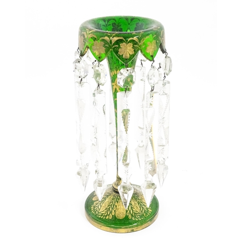 274 - A Victorian green glass table lustre with gilt foliate decoration and clear glass drops. Approx 13 1... 