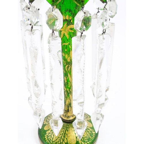 274 - A Victorian green glass table lustre with gilt foliate decoration and clear glass drops. Approx 13 1... 