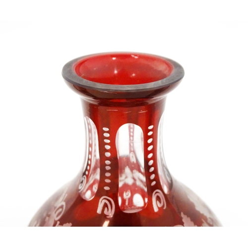 283 - A glass liquor decanter with red and etched detail depicting stag, bird, church, etc. Together with ... 