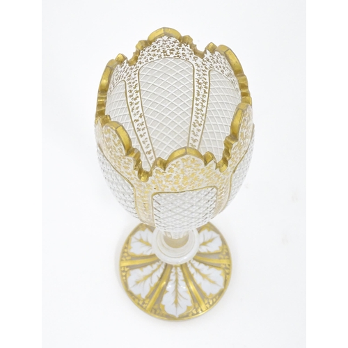 298 - A Victorian Bohemian diamond cut glass vase of pedestal tulip form with white and gilt detail. Appro... 