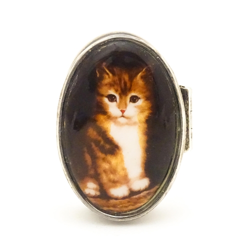 521 - A silver pill box with cabochon to top decorated with a cat / kitten. Approx. 1 1/2