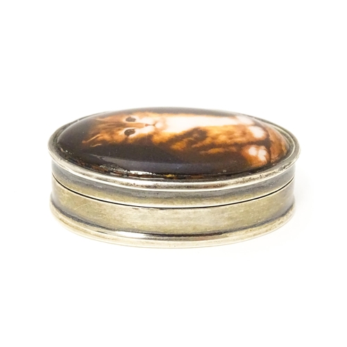 521 - A silver pill box with cabochon to top decorated with a cat / kitten. Approx. 1 1/2