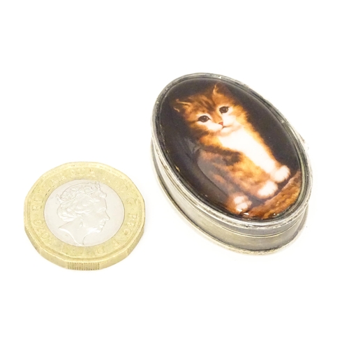 521 - A silver pill box with cabochon to top decorated with a cat / kitten. Approx. 1 1/2