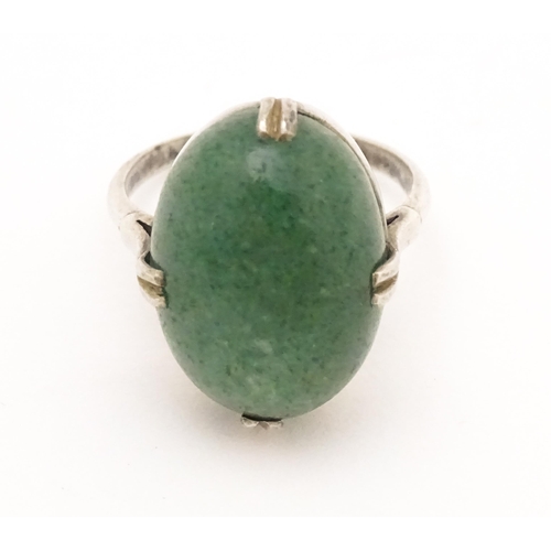 572 - An Art Deco white metal ring set with green stone cabochon. Ring size approx. N.