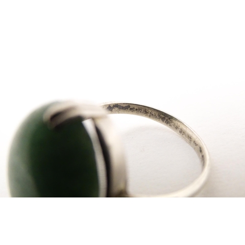 572 - An Art Deco white metal ring set with green stone cabochon. Ring size approx. N.