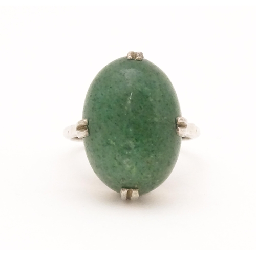 572 - An Art Deco white metal ring set with green stone cabochon. Ring size approx. N.