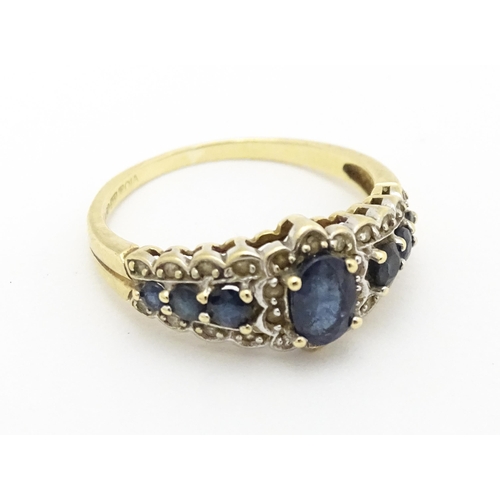 577 - A 9ct gold ring set with sapphires and diamonds. Ring size approx. P