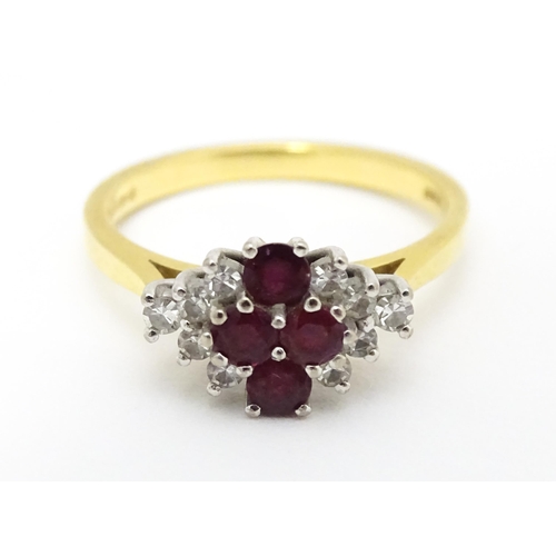 593 - An 18ct gold ring set with four rubies bordered by diamonds. Ring size approx. M