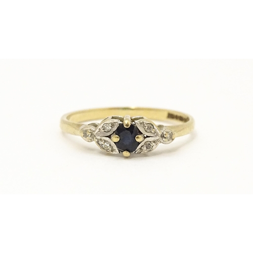 603 - A 9ct gold ring set with central spinel flanked by diamonds. Ring size approx. J 1/2