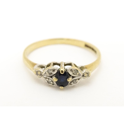 603 - A 9ct gold ring set with central spinel flanked by diamonds. Ring size approx. J 1/2