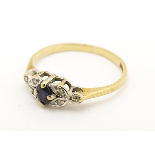 603 - A 9ct gold ring set with central spinel flanked by diamonds. Ring size approx. J 1/2