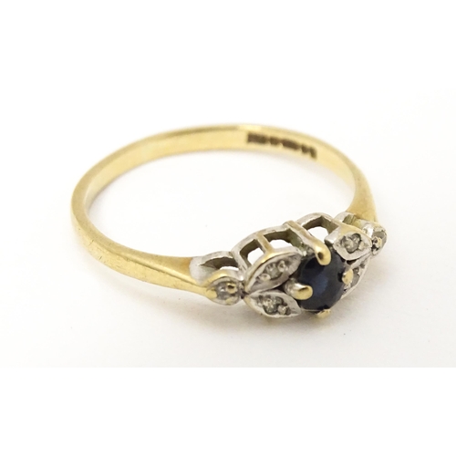 603 - A 9ct gold ring set with central spinel flanked by diamonds. Ring size approx. J 1/2