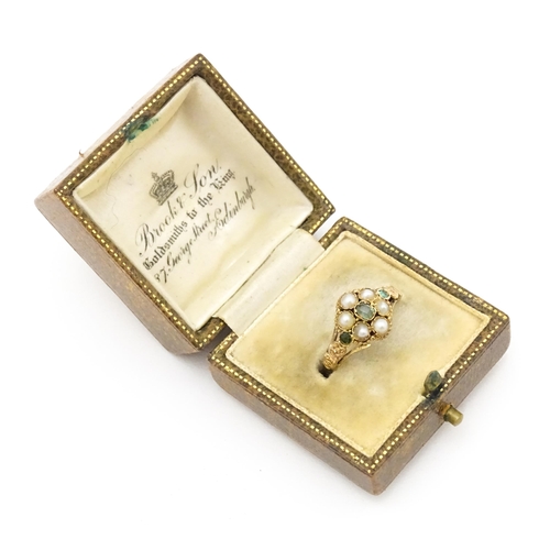 619 - A Victorian gold ring set with emeralds and pearls. Ring size approx. O