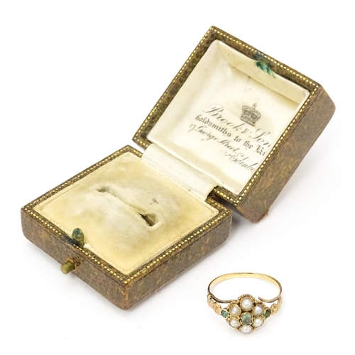 619 - A Victorian gold ring set with emeralds and pearls. Ring size approx. O