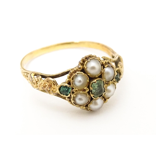 619 - A Victorian gold ring set with emeralds and pearls. Ring size approx. O