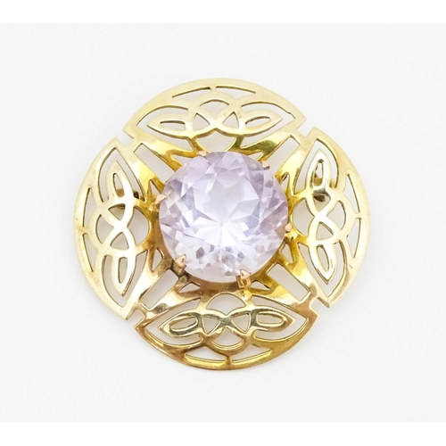 634 - A 9ct gold brooch set with central amethyst with Celtic decoration, hallmarked Birmingham 1966, 
mak... 