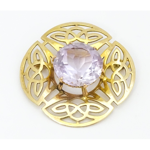 634 - A 9ct gold brooch set with central amethyst with Celtic decoration, hallmarked Birmingham 1966, 
mak... 