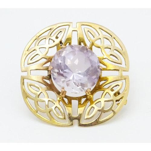 634 - A 9ct gold brooch set with central amethyst with Celtic decoration, hallmarked Birmingham 1966, 
mak... 