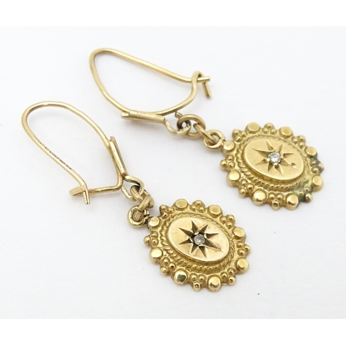 652 - A pair of 9ct gold drop earrings set with diamonds. Approx. 1