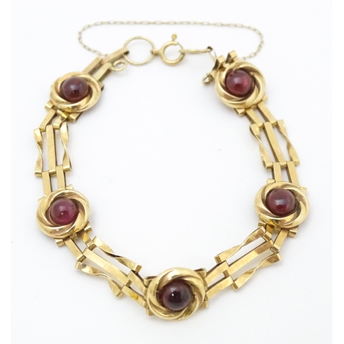 656 - A Victorian 9ct gold and yellow metal bracelet set with five garnet cabochons. Approx. 6