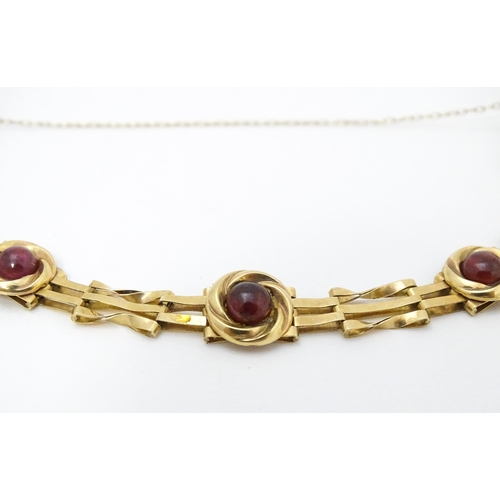 656 - A Victorian 9ct gold and yellow metal bracelet set with five garnet cabochons. Approx. 6