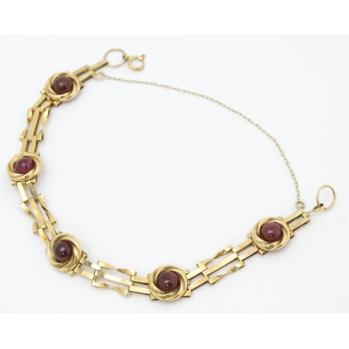 656 - A Victorian 9ct gold and yellow metal bracelet set with five garnet cabochons. Approx. 6