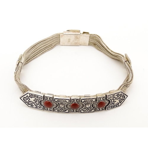 691 - A silver bracelet with five-strand detail and three carnelian coloured cabochon. Approx 7