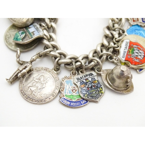 758 - A silver charm bracelet with various silver and silver plate charms, some coin formed.