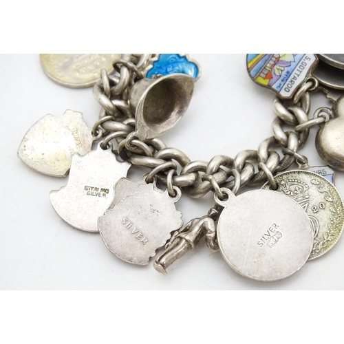 758 - A silver charm bracelet with various silver and silver plate charms, some coin formed.