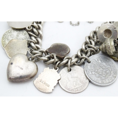 758 - A silver charm bracelet with various silver and silver plate charms, some coin formed.