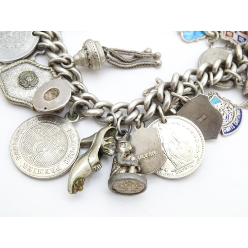 758 - A silver charm bracelet with various silver and silver plate charms, some coin formed.