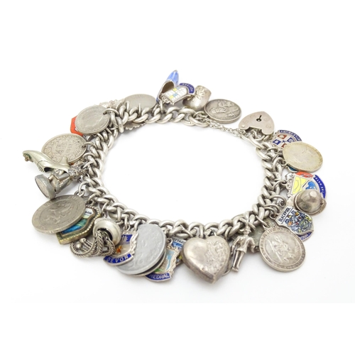 758 - A silver charm bracelet with various silver and silver plate charms, some coin formed.