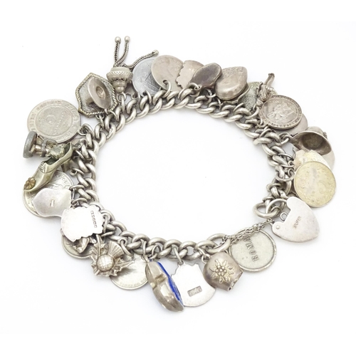 758 - A silver charm bracelet with various silver and silver plate charms, some coin formed.