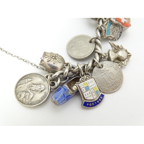 758 - A silver charm bracelet with various silver and silver plate charms, some coin formed.