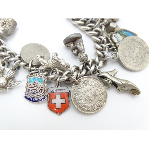 758 - A silver charm bracelet with various silver and silver plate charms, some coin formed.