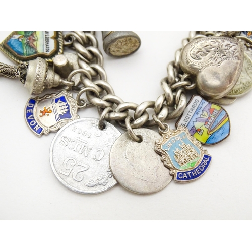 758 - A silver charm bracelet with various silver and silver plate charms, some coin formed.