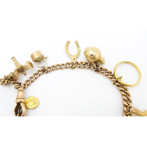 764 - A 9ct gold twin chain charm bracelet set with various 9ct gold and yellow metal charms to include a ... 