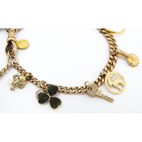 764 - A 9ct gold twin chain charm bracelet set with various 9ct gold and yellow metal charms to include a ... 