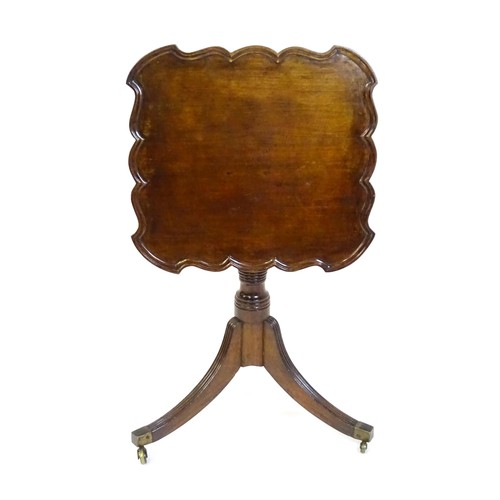 1432 - A late Georgian mahogany tripod table with a carved pie crust style top, a coil style turned pedesta... 