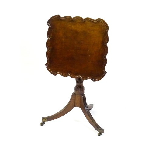 1432 - A late Georgian mahogany tripod table with a carved pie crust style top, a coil style turned pedesta... 