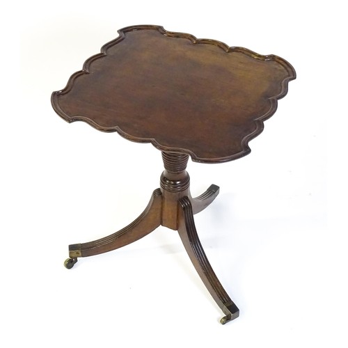 1432 - A late Georgian mahogany tripod table with a carved pie crust style top, a coil style turned pedesta... 