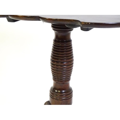 1432 - A late Georgian mahogany tripod table with a carved pie crust style top, a coil style turned pedesta... 